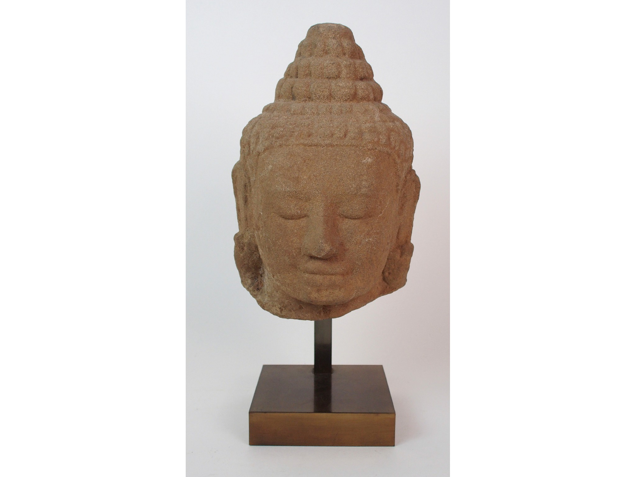 Appraisal: A Khmer sandstone head of Buddhawith serene smile with large