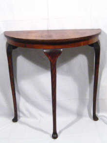 Appraisal: A semi-circular veneered side table on three long cabriole legs