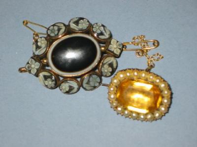 Appraisal: A VICTORIAN MOURNING BROOCH with central black onyx oval panel