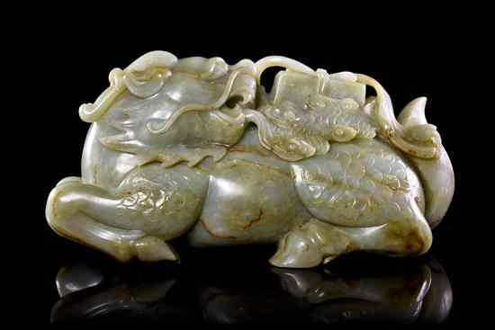 Appraisal: A Carved Jade Qiling Bearing a Book of celadon colored