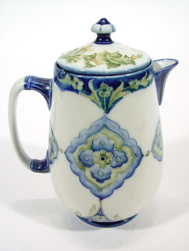 Appraisal: Moorcroft pottery hot water jug and a cover hand painted