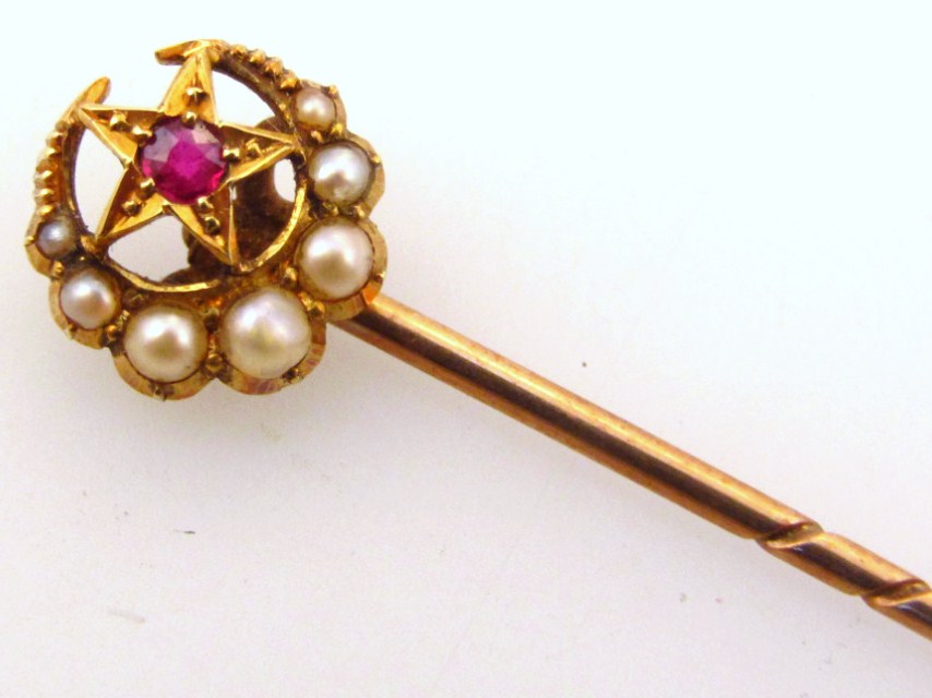 Appraisal: An Edwardian stick pin surmounted by a crescent set with