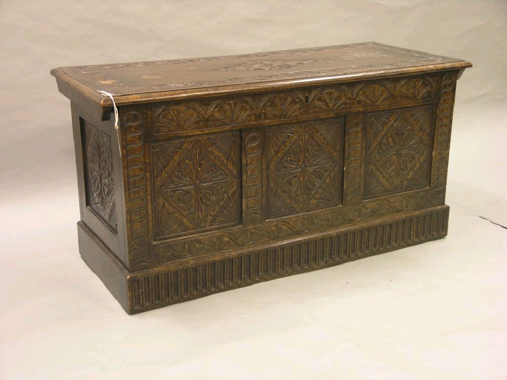 Appraisal: A solid dark oak coffer carved with lunettes and lozenges