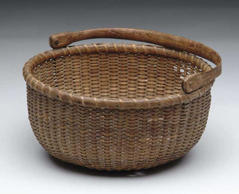 Appraisal: NANTUCKET SWING HANDLE BASKET Antique basket has carved wood swing