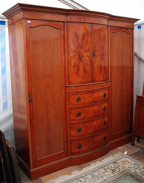 Appraisal: AN EDWARDIAN SATINWOOD TRIPLE WARDROBE with bowed central section twin