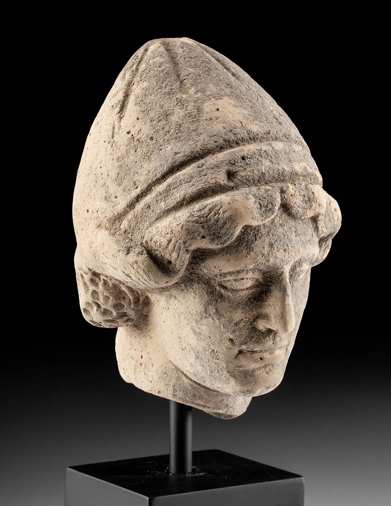 Appraisal: Greek Terracotta Head of a Youth Wearing Pilos Helmet Magna