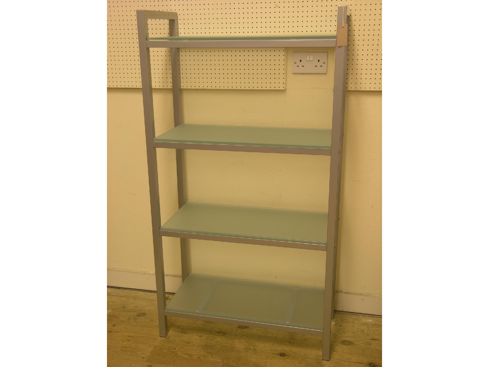 Appraisal: A metal-framed shelf unit four frosted glass shelves ft in