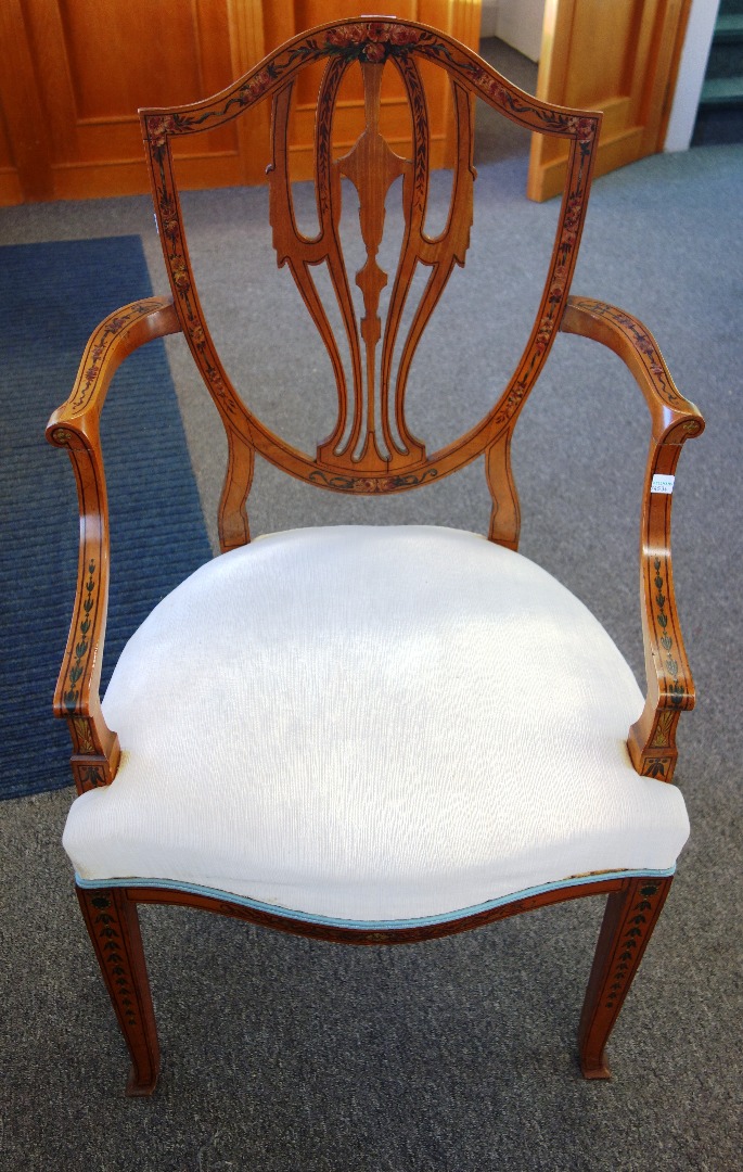 Appraisal: An Edwardian floral painted satinwood shield back open armchair on