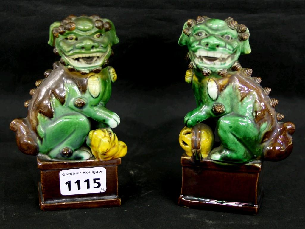 Appraisal: Pair of small pottery crouching dogs of Fo upon rectangular