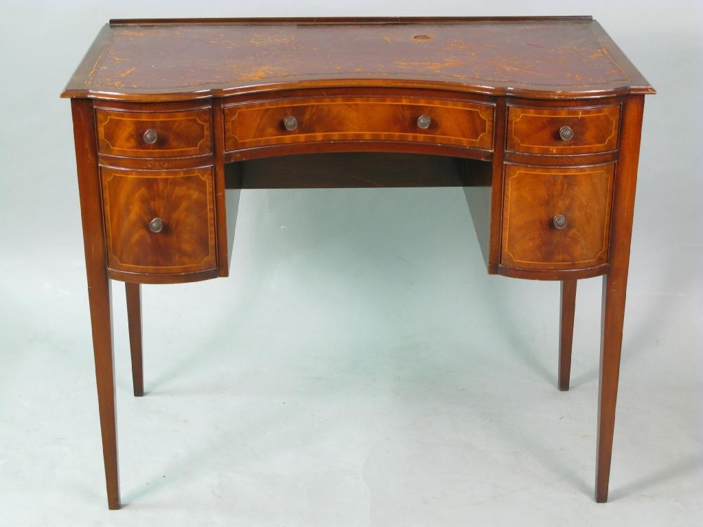 Appraisal: A reproduction inlaid mahogany writing table concave-fronted with leather top