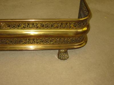 Appraisal: A BRASS FENDER of rounded oblong form the fascia pierced