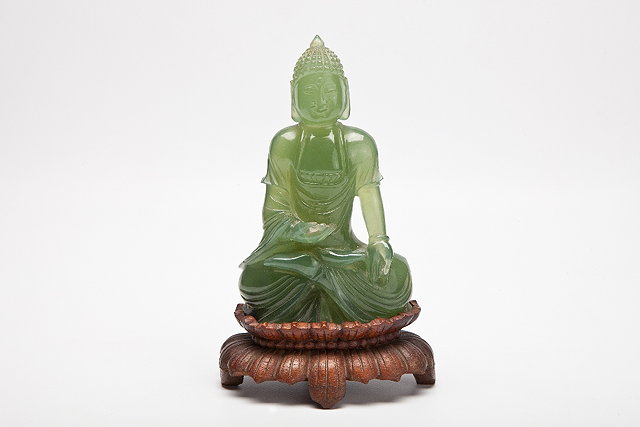 Appraisal: A CHINESE LEAF GREEN JADEITE FIGURE OF A SEATED BUDDHA