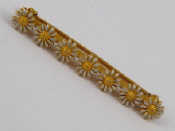 Appraisal: A yellow metal tests carat gold and enamel sunflower bar