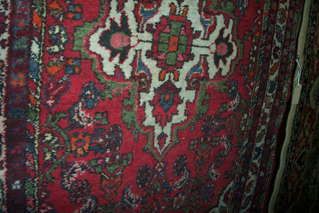 Appraisal: A red ground Eastern wool rug with central motif within