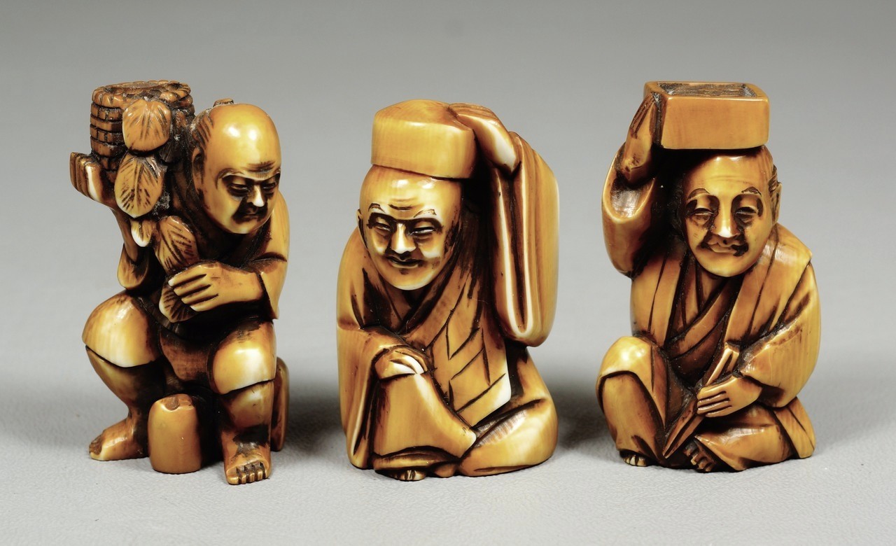 Appraisal: tea stained carved ivory Japanese netsuke men holding objects all