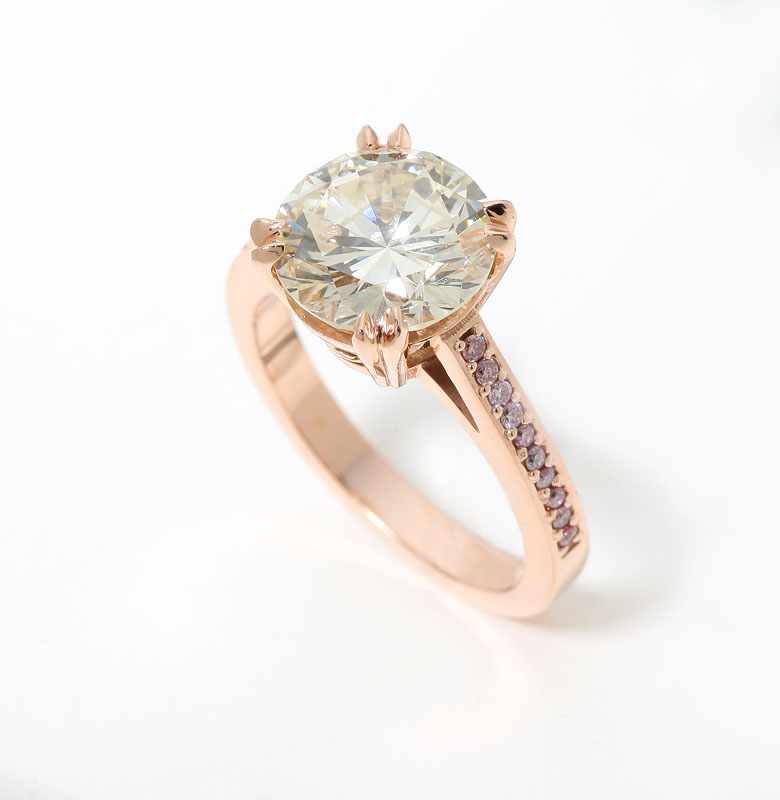 Appraisal: Tests K rose gold centering a round brilliant-cut diamond weighing