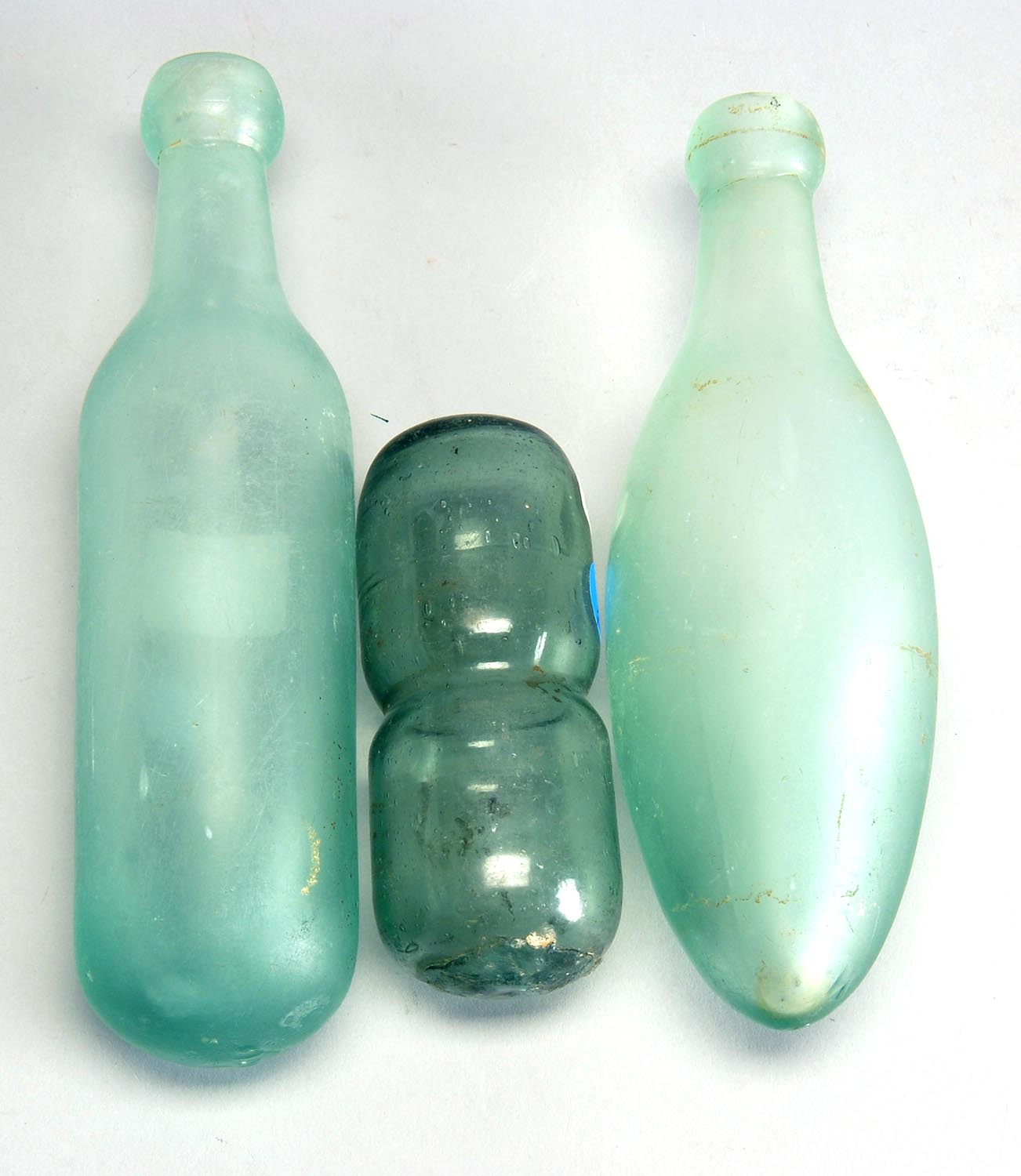 Appraisal: THREE GREEN GLASS ITEMS two bottles and a fish float