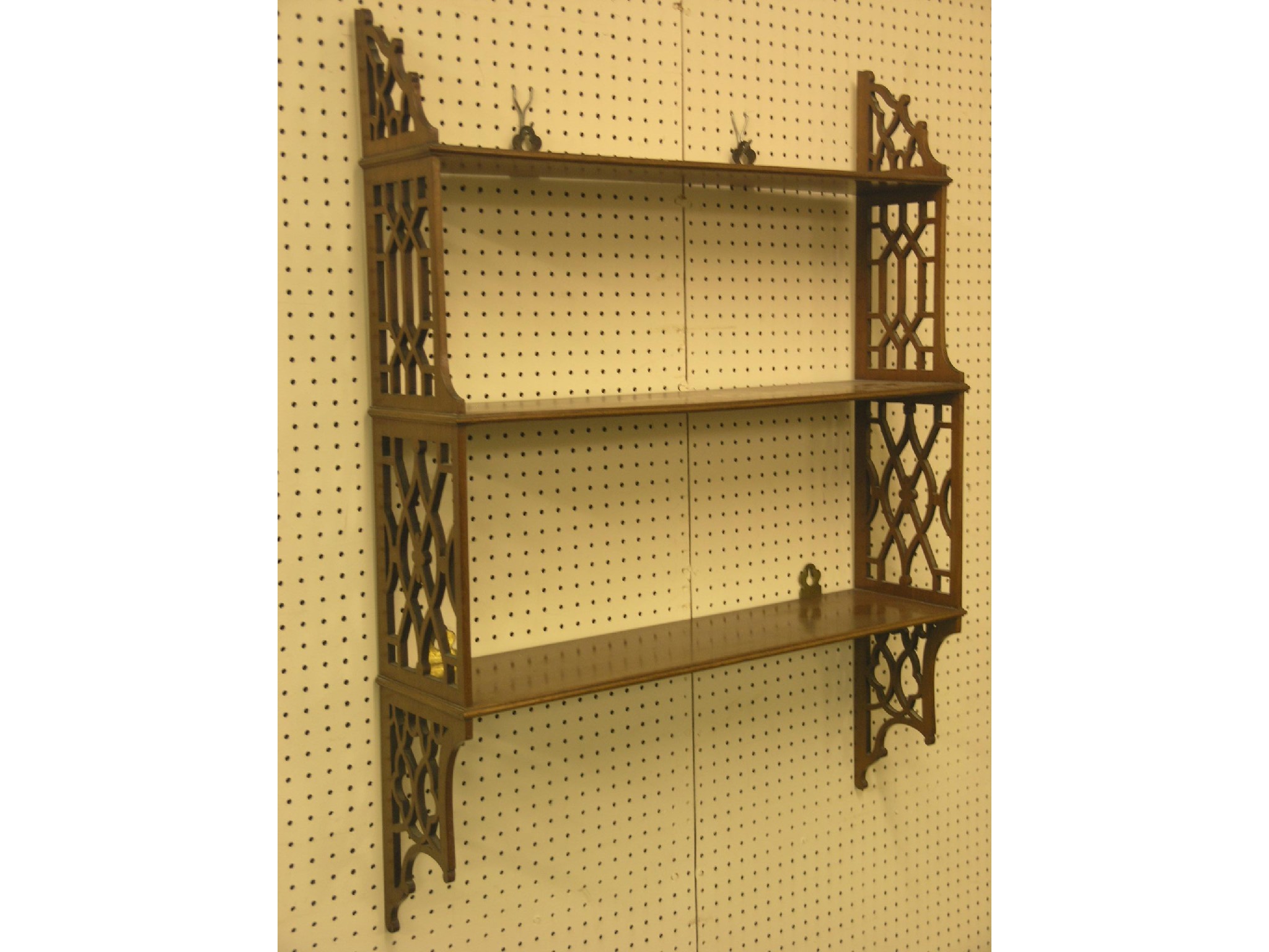 Appraisal: A Chippendale-style mahogany range of three shelves open lattice sides