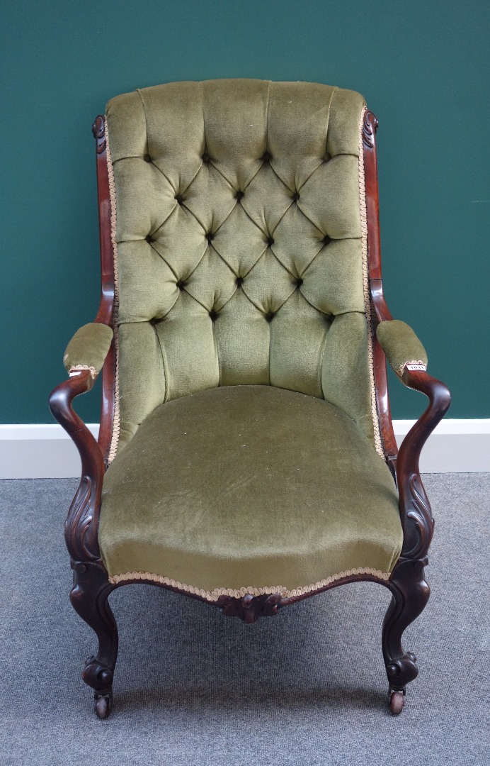 Appraisal: A Victorian rosewood framed open arm easy armchair with serpentine