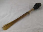 Appraisal: A long horn shoehorn with bald headed ugly man's head