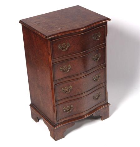 Appraisal: A miniature burr walnut serpentine chest the moulded top over