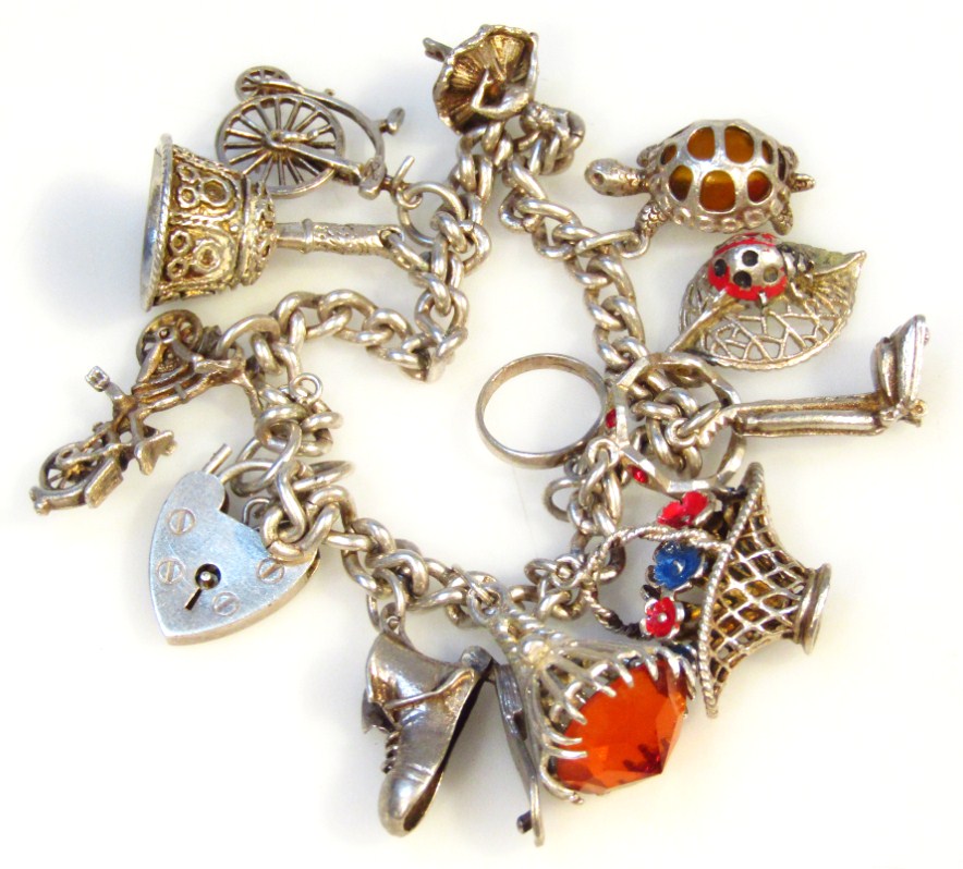 Appraisal: A silver charm bracelet with heart shaped clasp and a