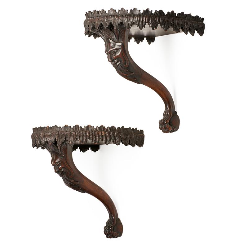 Appraisal: PAIR OF IRISH MAHOGANY WALL BRACKETS Carved mask faces with