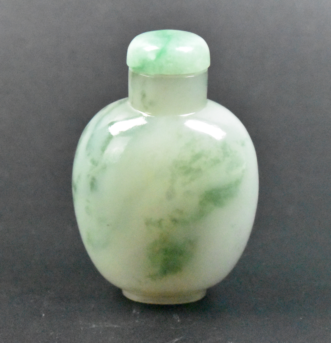 Appraisal: A Chinese jadeite carved snuff bottle Smooth rounded form with