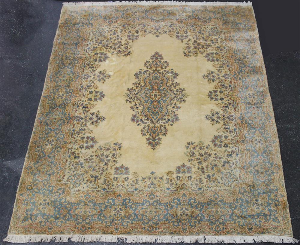 Appraisal: LARGE KIRMAN WOOL RUG ivory field with colors including blues