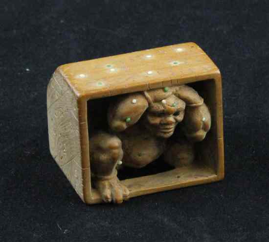 Appraisal: A Meiji period bead inset hardwood netsuke carved as an