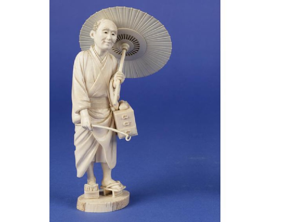 Appraisal: A JAPANESE IVORY FIGURE OF A MAN holding a parasol