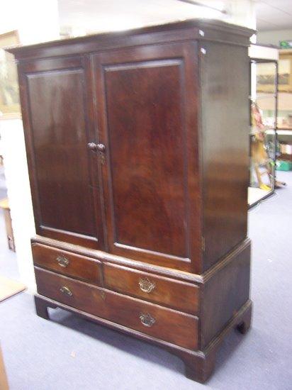 Appraisal: A mahogany linen press with glazed door the panel doors