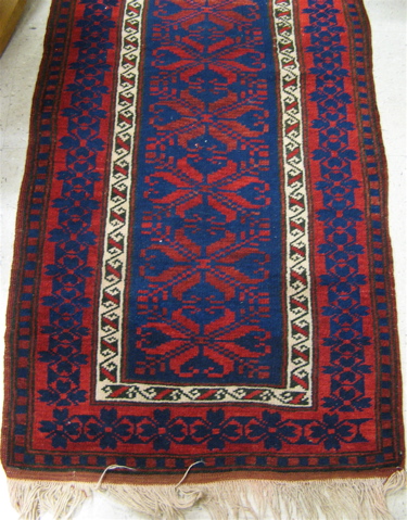 Appraisal: AFGHANI TRIBAL RUNNER overall geometric curvilinear decoration in red and