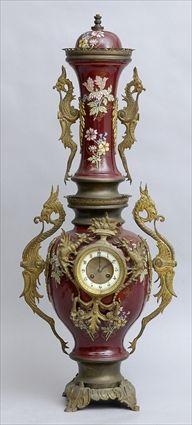 Appraisal: RENAISSANCE-STYLE GILT-METAL MOUNTED MAROON-GROUND ENAMELED-CERAMIC CLOCK The in chapter ring