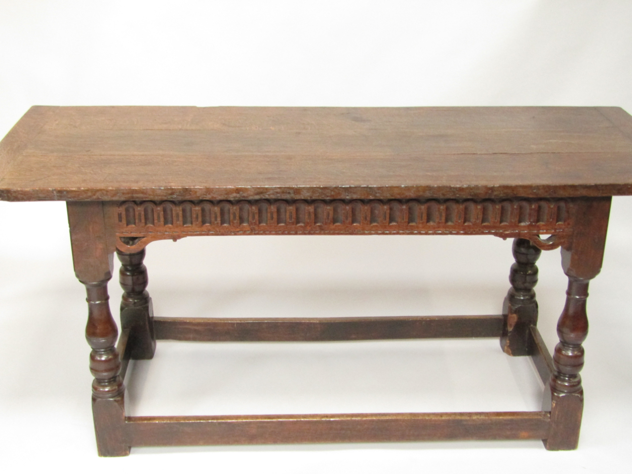 Appraisal: A thC oak refectory dining table with a carved frieze