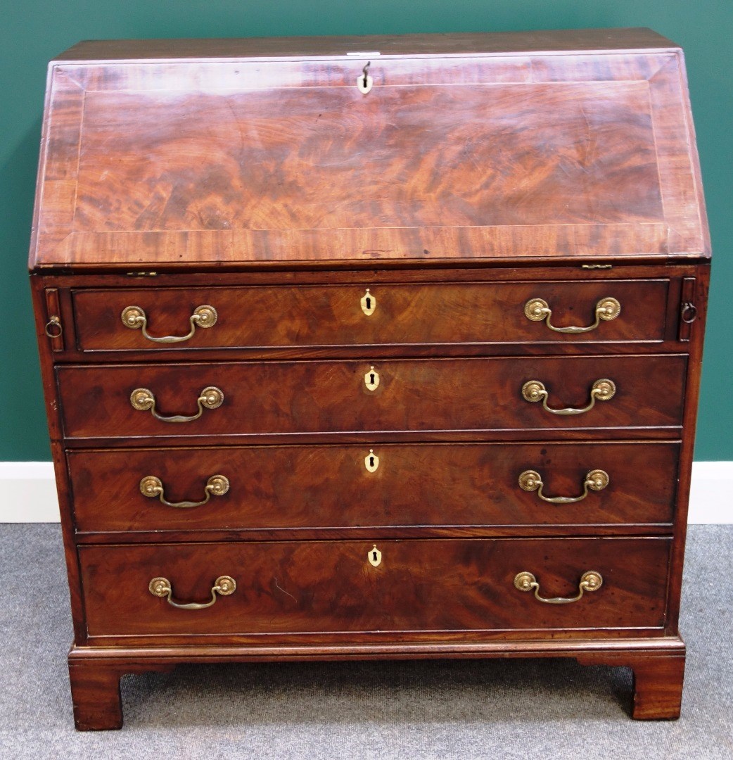 Appraisal: A George III mahogany bureau the fall revealing a fitted