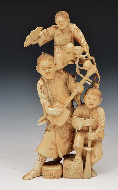 Appraisal: A Japanese walrus ivory okimono of a street entertainerMeiji periodthe