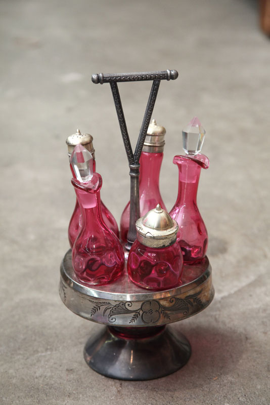 Appraisal: CASTER SET Five cranberry condiment bottles with thumbprint decoration in