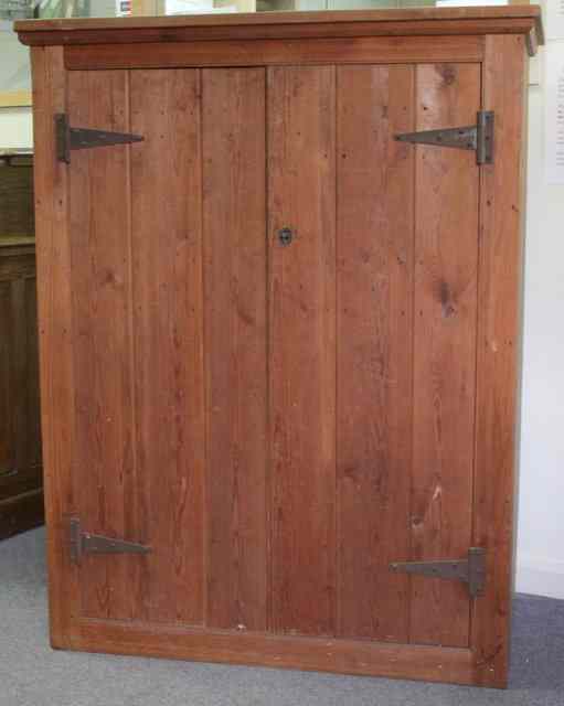 Appraisal: A pitch pine cupboard enclosed by a pair of triple