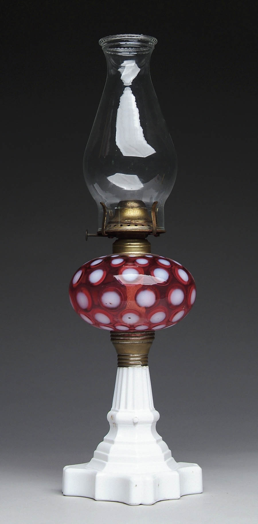 Appraisal: GLASS AND BRASS KEROSENE LAMP Squashed ball font in cranberry