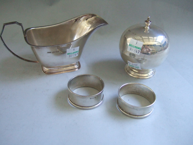 Appraisal: Silver comprising a sauceboat with an angular handle two napkin