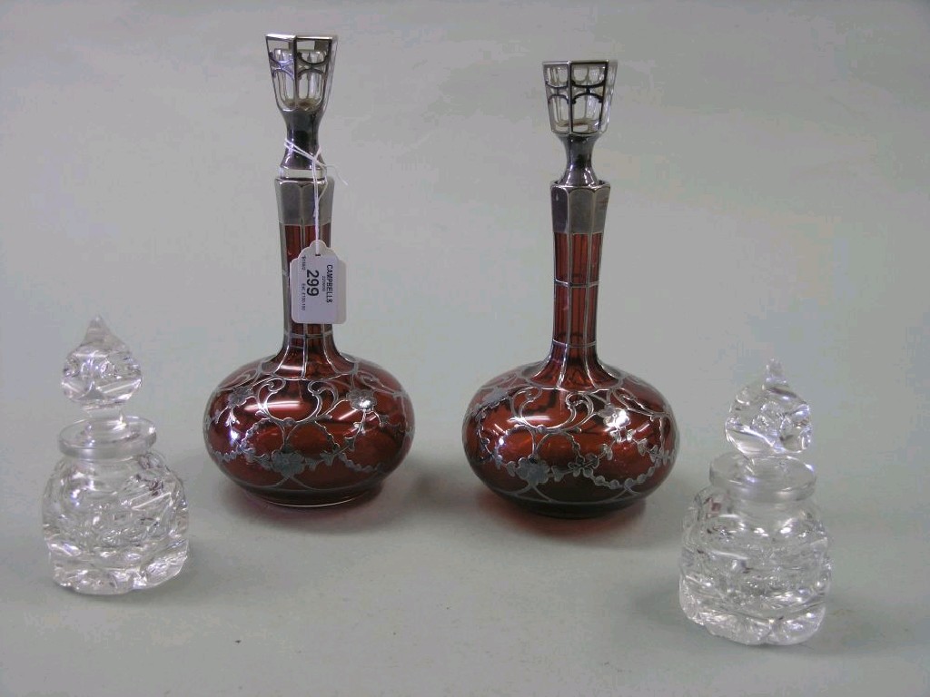 Appraisal: A pair of ruby glass and silver overlaid bottles globe-and-shaft