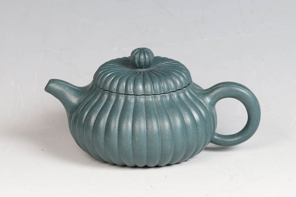 Appraisal: YIXING GREEN CLAY TEAPOT The compressed body finely molded with