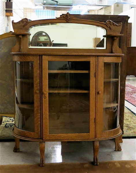 Appraisal: LOW OAK AND CURVED GLASS CHINA CABINET American c the