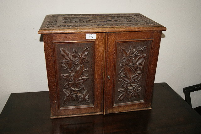 Appraisal: Victorian oak enclosed smoker's cabinetwith carved decoration and oval crest