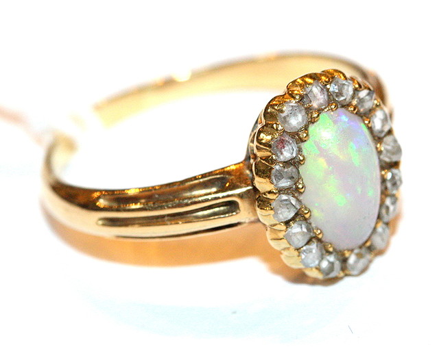 Appraisal: AN OPAL AND DIAMOND SET CLUSTER RING oval bead set