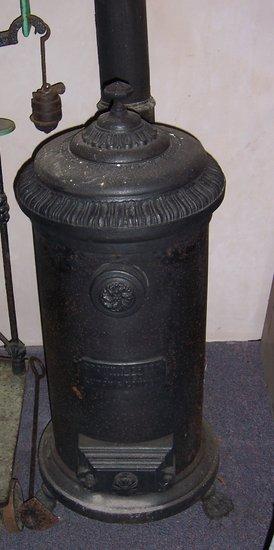 Appraisal: A cylindrical cast iron stove with cover on paw feet