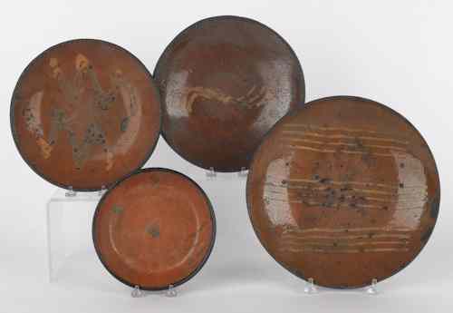 Appraisal: Four Pennsylvania redware plates th c three with slip decoration