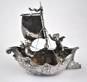 Appraisal: A silver miniature boat sailed by a cherub import mark