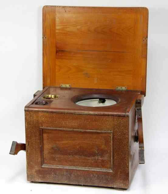 Appraisal: A stained pine commode the hinged cover enclosing ceramic bowl